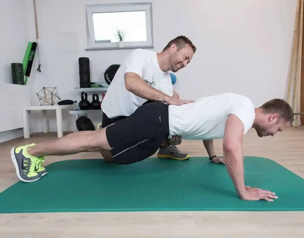 Trainer korrigiert Haltung beim Sport